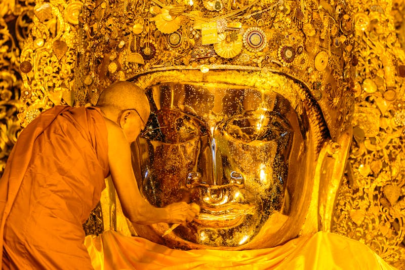 Ein Mönch reinigt den goldenen Buddha in der Mahamuni-Pagode in Mandalay - ©©siamphoto - stock.adobe.com