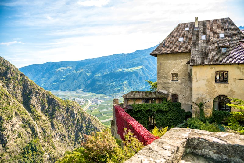 Altes Schloss Juval, historisch Südtirol mit rotem Weinlaub und Bergen im Hintergund - ©©Sonja - stock.adobe.com