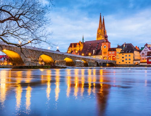 Winterabend in Regensburg - Blick auf die Steinerne Brücke, die Donau und sie Altstadt – © ©emperorcosar - stock.adobe.com