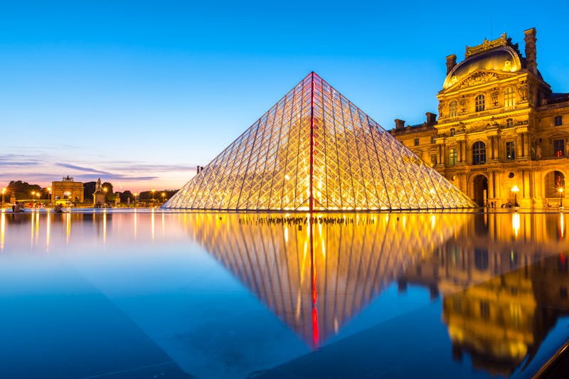 Louvre in Paris - hell erleuchtete Pyramide am Abend - ©©vichie81 - stock.adobe.com