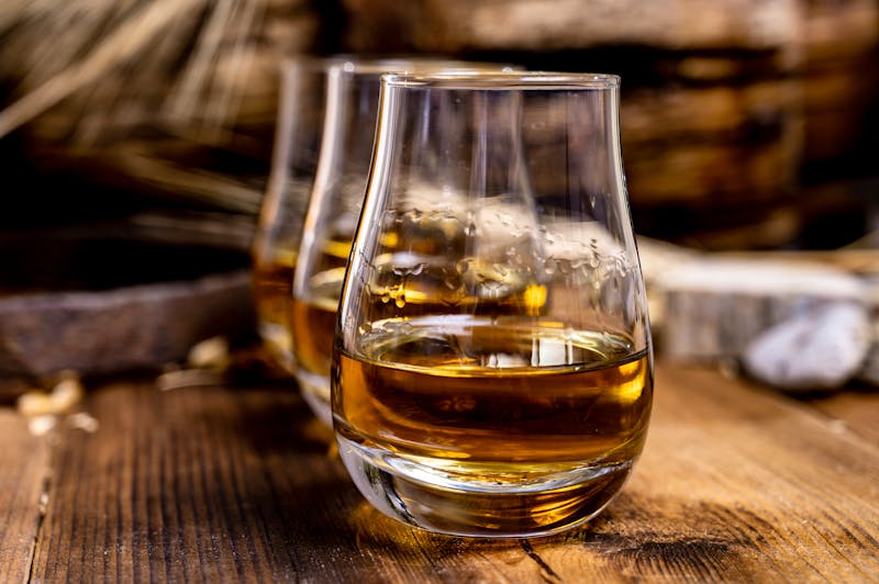 Speyside scotch whisky tasting on old dark wooden vintage table with barley grains - ©©barmalini - stock.adobe.com