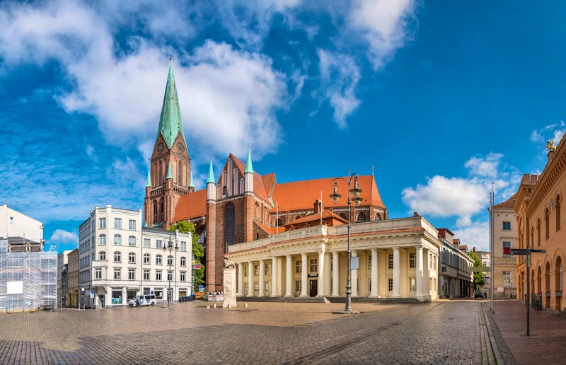 Schwerin - Marktplatz mit Dom, Löwendenkmal und dem Säulengebäude - ©bbsferrari - adobeStock.com