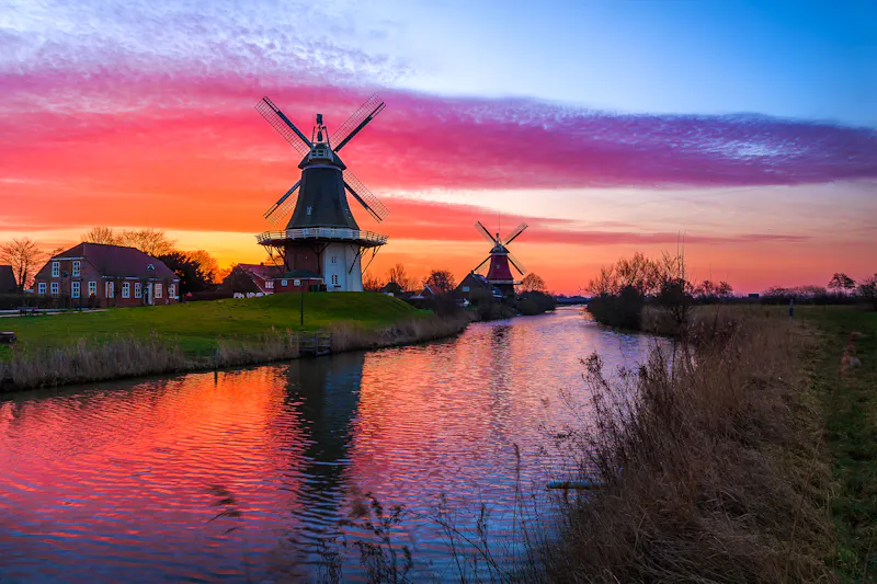 Greetsiel in Ostfriesland - die Zwillings-Windmühlen im Abendrot - &copy;rphfoto - stock.adobe.com