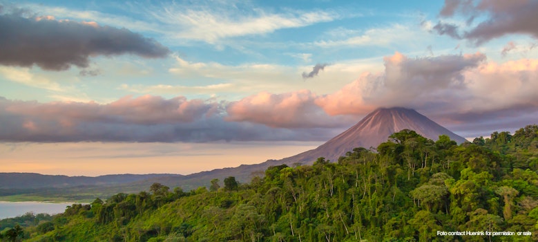 Arenal Volcano at Sunrise in Costa Rica, as the sun reflects on the newly formed clouds – © contact Huenink for permission  or sale