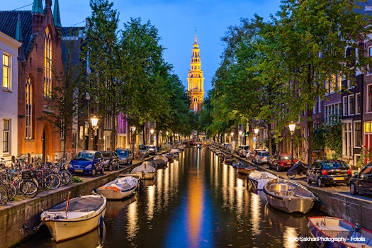 Traditional view of canals in Amsterdam where boats  bicycles and cars on same street  – © SakhanPhotography - Fotolia