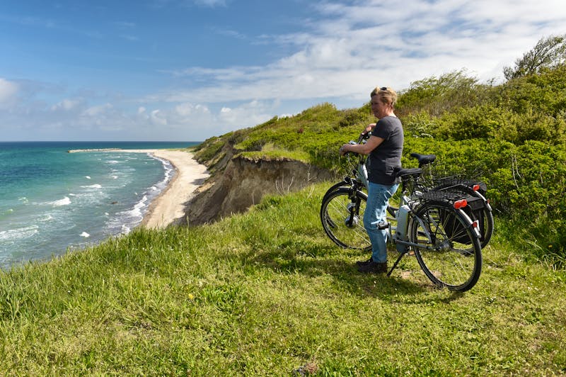 Ostseeküste - Fahrradfahrerin genießt den Blick über das Meer - ©dieter76 - stock.adobe.com