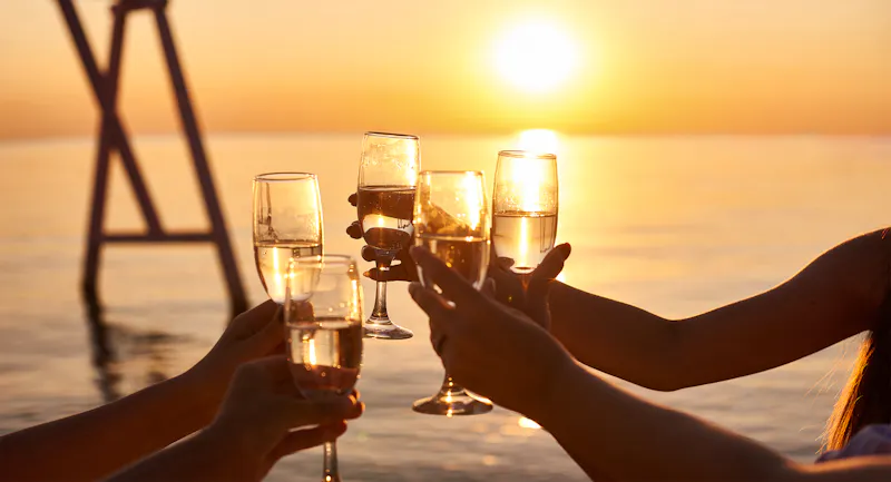 Sonnenuntergang mit Sekt am Strand - &copy;cenchild - stock.adobe.com