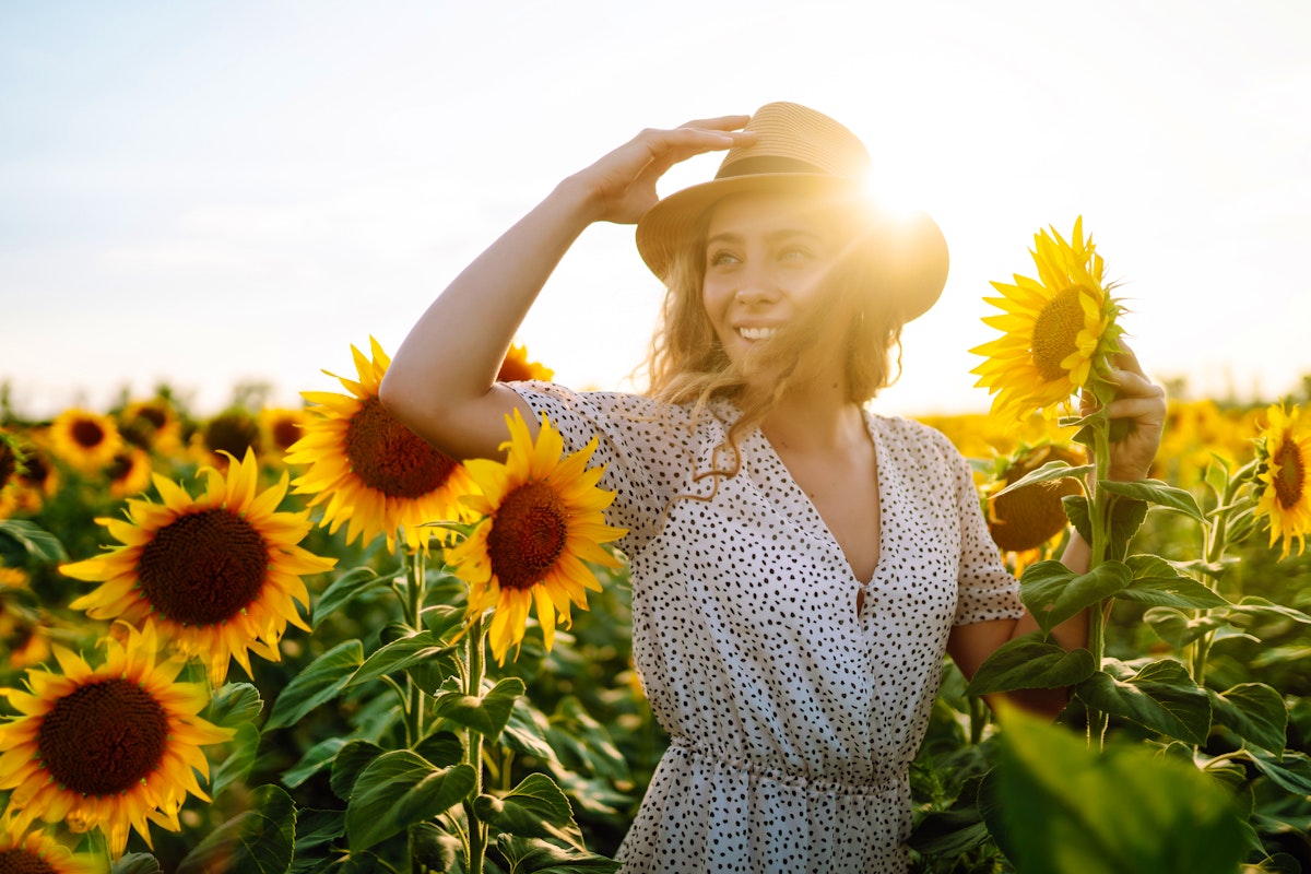 Spätsommer an einem Sonnenblumen-Feld - junge Frau genießt die Sonne – © maxbelchenko - stock.adobe.com