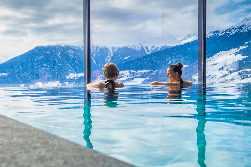 Frauen im Urlaub geniessen Bergpanorama vom Pool aus - © mmphoto - stock.adobe.com