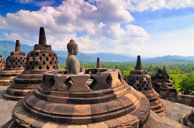 Stupas und Buddha-Statue am Borobodur Tempel auf Java - ©GISTEL - stock.adobe.com