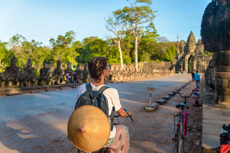 Touristin entdeckt die Tempelanlagen von Angkor mit dem Fahrrad - Haupteingang von Angkor Thom - ©fabio lamanna - stock.adobe.com