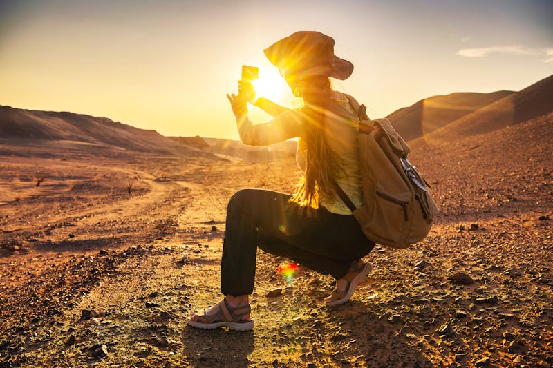 Sonnenuntergang in der Wüste Gobi - Touristin fotografiert das Naturschauspiel - ©cppzone - stock.adobe.com