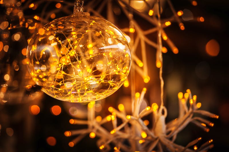 Glaskugel und beleuchtete Girlande auf einem Weihnachtsmarkt im Trentino - ©nata_rass - stock.adobe.com