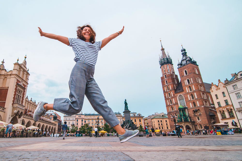 Krakau - junge Frau auf dem Marktplatz, die Marienbasilika im Hintergrund &ndash; &copy; phpetrunina14 - stock.adobe.com