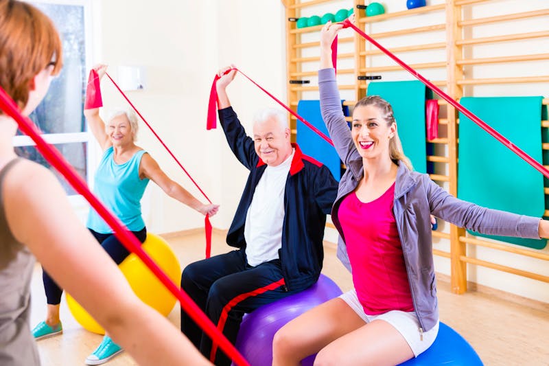 Senior people at fitness course in gym exercising with stretch band – ©Kzenon - Fotolia