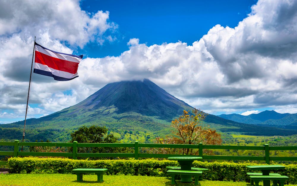 Rastplatz mit Blick auf den Vulkan Arenal bei La Fortuna mit der Flagge von Costa Rica &ndash; &copy; Valerija Dmitrijeva - stock.adobe.com