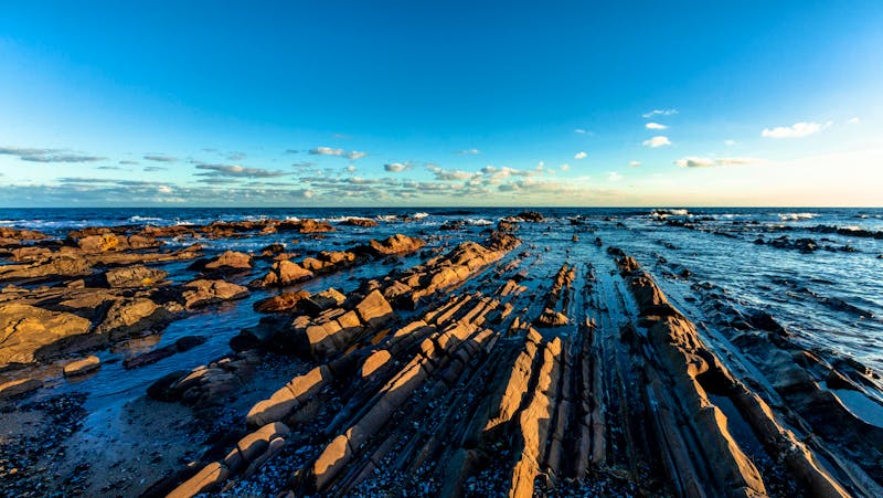 Vor dem Leuchtturm prägen schroffe Felsen das Meer - &copy;Zé Roberto Muniz - stock.adobe.com