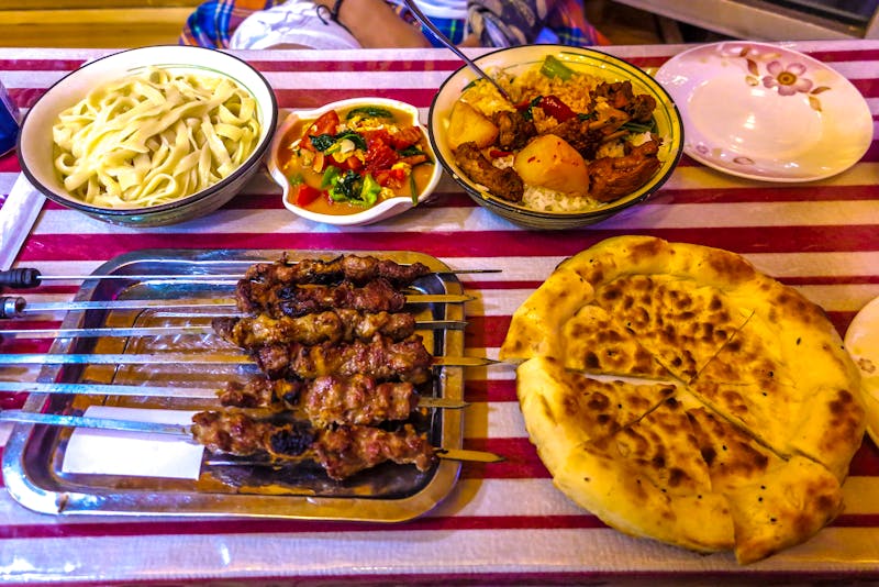 Traditionelle uigurische Speisen: scharfe Lammspieße mit Kreuzkümmel und Naan-Brot - &copy;Aleksandar - stock.adobe.com