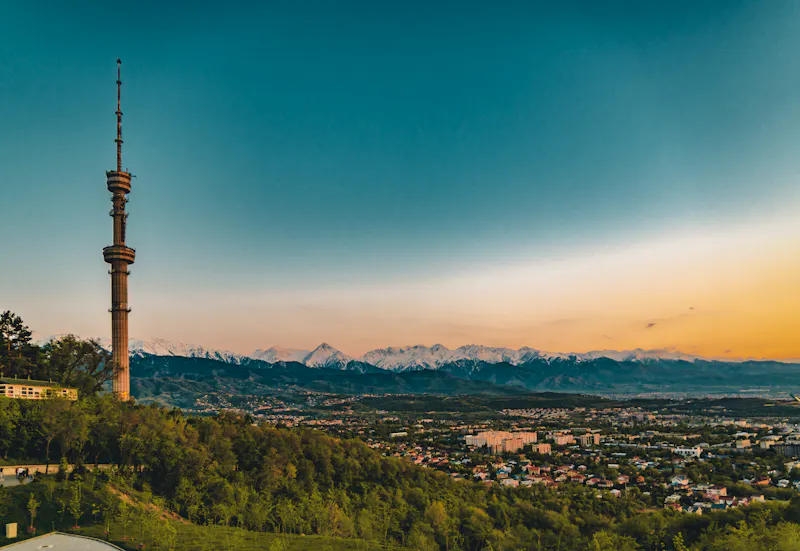 Sonnenuntergang über der Stadt Almaty und Blick auf den Fernsehturm auf dem Berg Kök-Töbe - &copy;Mathias - stock.adobe.com