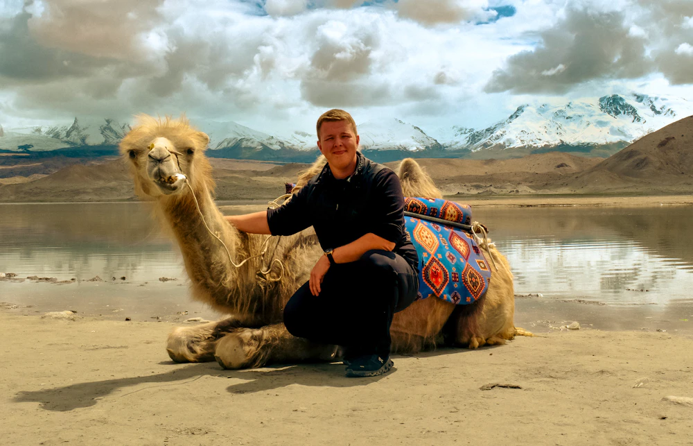 Sten Bernhardt mit einem Kamel am Karakol-See in Xinjiang, China – © Sten Bernhardt